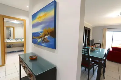 a kitchen and dining room with a painting on the wall at Terraços de Vilamoura 55- Clever Details in Vilamoura