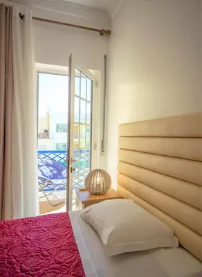 a bedroom with a bed and a view of a patio at Olhos de Água Apartment Albufeira II in Albufeira