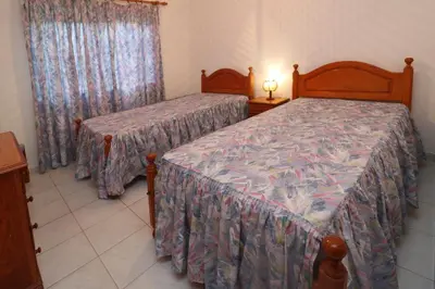 a bedroom with two beds and a window at Villa Estela in Albufeira