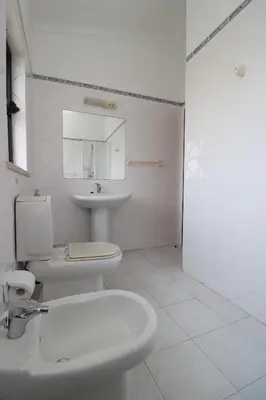 a bathroom with a white toilet and a sink at Villa Estela in Albufeira