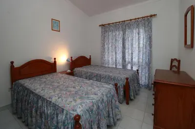 a hotel room with two beds and a window at Villa Estela in Albufeira