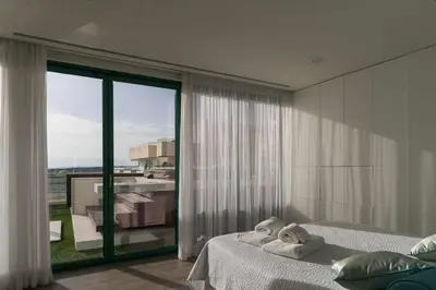 a bedroom with two beds and a large window at Marina Vilamoura Penthouse Aquamar 606 in Vilamoura