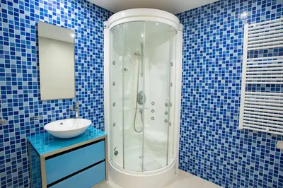 a blue tiled bathroom with a shower and a sink at Marina Vilamoura - Aquamar 215 - VilamouraSun in Vilamoura