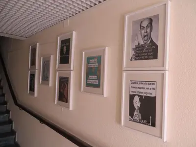 a wall with framed pictures on a wall at Guest House Oliveira in Boliqueime