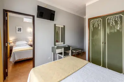 a bedroom with a bed and a mirror at Guest House Oliveira in Boliqueime
