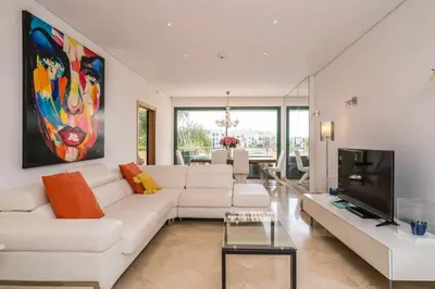 a living room with a white couch and a tv at VilamouraSun Aquamar 110 - Pool and Marina View in Vilamoura