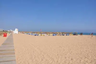 a sandy beach with a pier and a group of buildings at Marina Vilamoura - Aquamar 013 - By VilamouraSun in Vilamoura