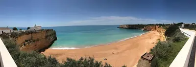 a boat in the water at sunset on the beach at Apartment Albufeira Algarve in Albufeira