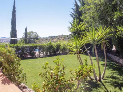 a garden with palm trees and a volley ball hoop at Holiday Home Montinho by Interhome in Loulé
