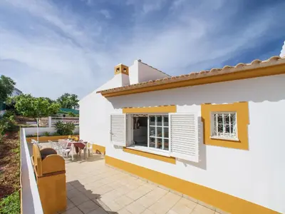 a white house with a patio with a table and chairs at Holiday Home Monte Novo by Interhome in Paderne