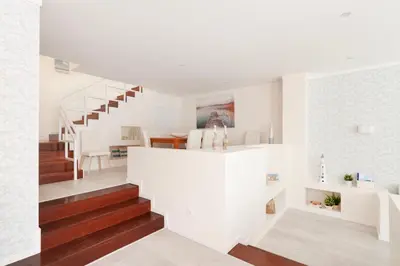 a white room with a staircase and a living room at Vila dos Lírios - Blue Sea in Albufeira