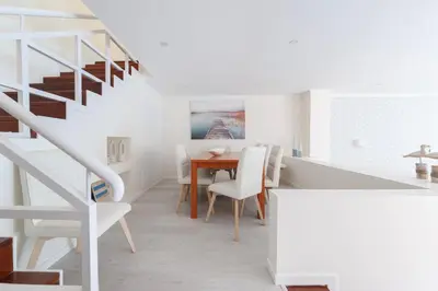a dining room with a table and white stairs at Vila dos Lírios - Blue Sea in Albufeira