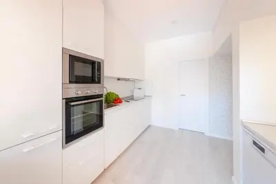 a kitchen with white cabinets and a microwave at Vila dos Lírios - Blue Sea in Albufeira