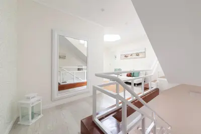 a staircase in a white room with a mirror at Vila dos Lírios - Blue Sea in Albufeira