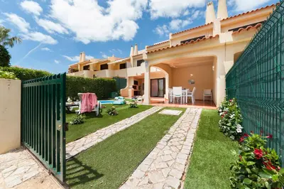 a backyard of a house with a fence and grass at Vila dos Lírios - Blue Sea in Albufeira