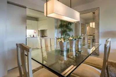 a dining room with a glass table with flowers on it at Solar do Golfe apt 101 - By Vilamoura Sun in Vilamoura
