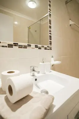a white bathroom with a toilet and a sink at Oura Parque Apartamentos Turisticos in Albufeira