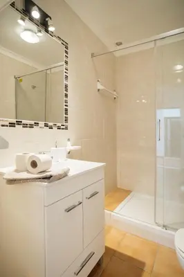 a bathroom with a white sink and a shower at Oura Parque Apartamentos Turisticos in Albufeira