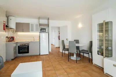 a kitchen and dining room with a table and chairs at Oura Parque Apartamentos Turisticos in Albufeira