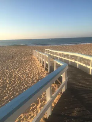 a wooden boardwalk on a beach with the ocean at Vilamoura Garden House - Golf & Beach in Vilamoura