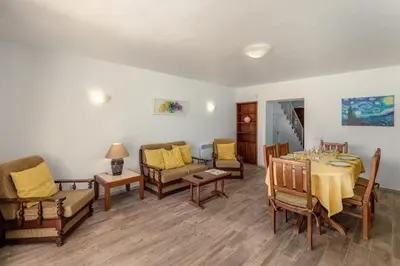 a living room with a table and chairs at Moradias Villas Joinal in Albufeira