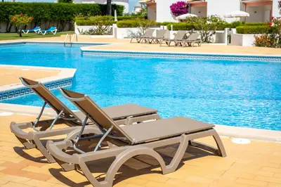 two lounge chairs sitting next to a swimming pool at Moradias Villas Joinal in Albufeira