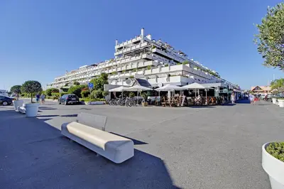 a building with tables and umbrellas in a parking lot at Marina Sagres Apartment in Vilamoura
