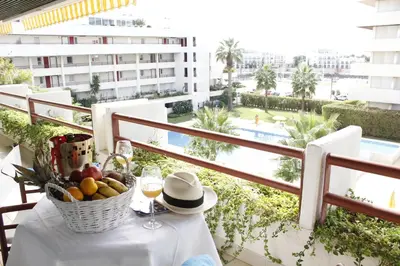 a table with a basket of fruit on a balcony at Marina Sagres Apartment in Vilamoura