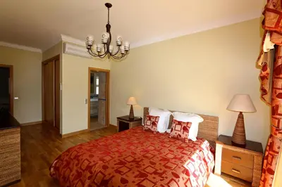 a bedroom with a bed and a chandelier at Villa Corvo 123- Clever Details in Vilamoura