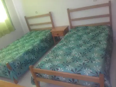 two twin beds in a room with a night stand at Albufeira INN - Elimar 3 T1 in Albufeira