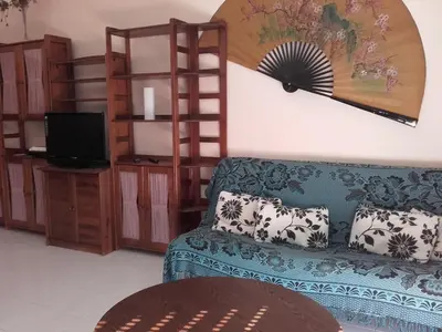 a living room with a blue couch and a tv at Albufeira INN - Elimar 5 T1 in Albufeira