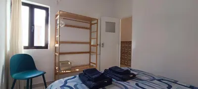a bedroom with a bed and a chair and a window at Casa do Sol in Albufeira