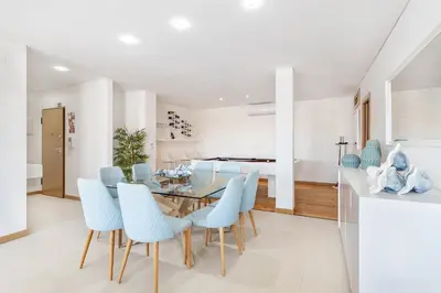 a dining room with a glass table and blue chairs at Garden Hill Relax & Old Town by OCvillas in Albufeira