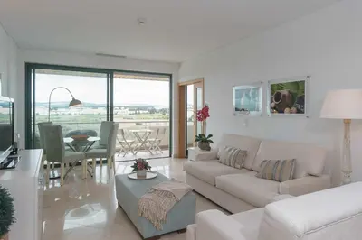 a living room with a white couch and a table at Marina Vilamoura Aquamar 504 by VilamouraSun in Vilamoura