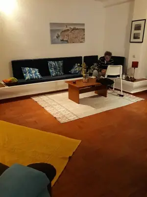 a man sitting on a couch in a living room at House with beautiful garden and swimming pool in Quarteira