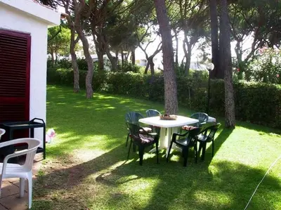 a table and chairs in a yard with trees at House with beautiful garden and swimming pool in Quarteira