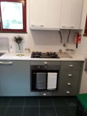 a kitchen with a stove top oven next to a window at House with beautiful garden and swimming pool in Quarteira