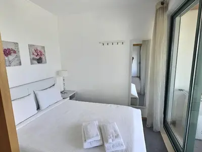 a bedroom with a white bed with two towels on it at Marina Vilamoura - Aquamar 301 - By Vilamoura Sun in Vilamoura