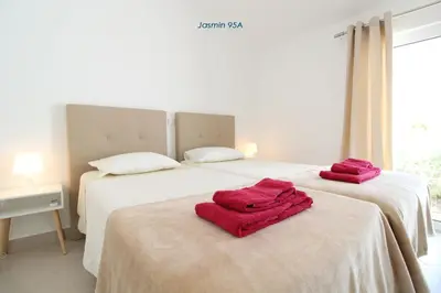 a table with two vases and two oranges on it at Apartamentos São Rafael - Albufeira, Algarve in Albufeira