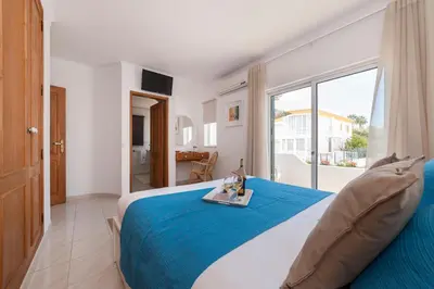 a bedroom with a large bed and a large window at Vila dos Girassóis - BlueSea in Albufeira
