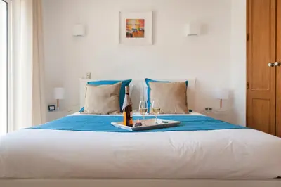 a bed with a tray with a candle and glasses on it at Vila dos Girassóis - BlueSea in Albufeira