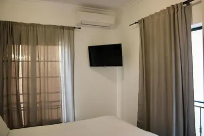 a bedroom with a bed and a television on the wall at Encosta das Oliveiras 49D in Vilamoura