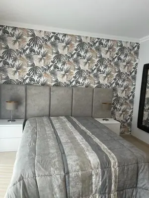 a bedroom with a large bed with a floral wallpaper at Vila Branca in Albufeira