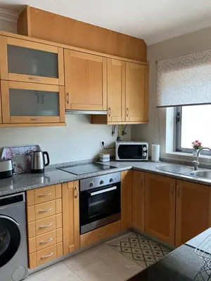 a kitchen with wooden cabinets and a stove top oven at Vila Branca in Albufeira