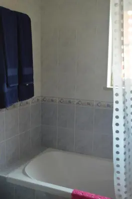 a white bath tub in a bathroom with blue towels at Villa Coelho - By Algarkasa in Albufeira