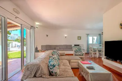 a living room with a couch and a tv at Villa Amendoeira-POOL HEATED - By Algarkasa in Guia