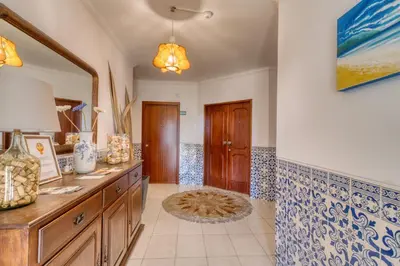 a bathroom with a sink and a wooden cabinet at Casa Teles in Quarteira