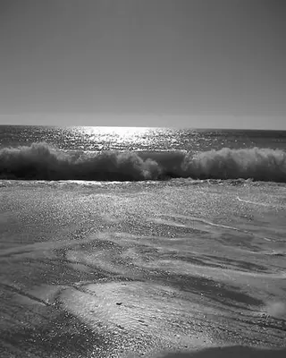 a beach with a wave in the ocean at Villas King's in Albufeira