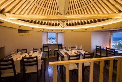 a dining room with tables and chairs and windows at Windmill Hill in Albufeira