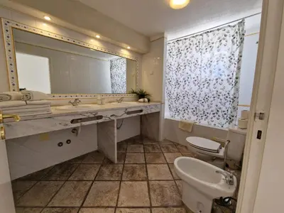 a bathroom with a sink and a toilet and a mirror at Windmill Hill in Albufeira